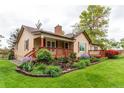 Charming single Gathering home with a front porch, landscaped yard, and brick chimney at 7785 W 5Th Ave, Lakewood, CO 80226