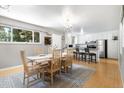Inviting dining area open to kitchen, with a wood table, seating for six, and modern lighting fixture at 2502 S Lima St, Aurora, CO 80014