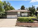 Well-maintained brick home with mature landscaping, three-car garage, and inviting front entry at 2502 S Lima St, Aurora, CO 80014