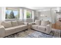 Bright living room with neutral paint, large windows, and comfortable seating area at 2502 S Lima St, Aurora, CO 80014