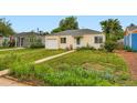 Lovely yellow home featuring a green door, well-maintained lawn, and a one car garage, blending comfort and charm at 1237 Tamarac St, Denver, CO 80220