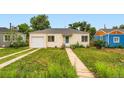 Quaint yellow home with a white garage door and lush green lawn, offering curb appeal and suburban charm at 1237 Tamarac St, Denver, CO 80220