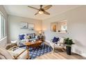 Cozy living room featuring stylish furniture, a modern ceiling fan, and an open view to the adjacent kitchen area at 1237 Tamarac St, Denver, CO 80220