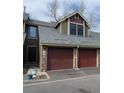 Charming home exterior features a two-car garage, muted color palette, and manicured front yard at 10806 W Evans Ave # 5, Lakewood, CO 80227