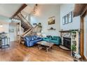 Bright living room with hardwood floors, stone fireplace, and exposed wood beam staircase at 10806 W Evans Ave # 5, Lakewood, CO 80227