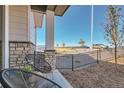 Cozy front porch with seating area overlooking a professionally landscaped front yard at 95 N Vandriver Pl, Aurora, CO 80018