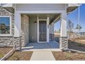Inviting front porch featuring stone accents, modern lighting and a stylish front door at 95 N Vandriver Pl, Aurora, CO 80018