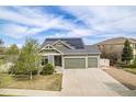 Charming home featuring an attached two car garage, solar panels, and a well-manicured lawn at 4873 Cathay Ct, Denver, CO 80249