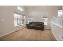 A cozy living room offers neutral carpet, large windows, and an open feel to the rest of the home at 7506 Chipmunk Pl, Littleton, CO 80125