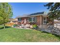 Charming brick home with a well-manicured lawn and inviting outdoor seating area on the patio at 6925 W 27Th Ave, Wheat Ridge, CO 80033