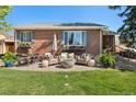 Cozy brick patio with comfortable outdoor seating and a modern fire pit, perfect for relaxing evenings at 6925 W 27Th Ave, Wheat Ridge, CO 80033