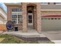 Inviting front porch with comfortable seating, brick accents, and a two-car garage at 5368 Creek Way, Parker, CO 80134