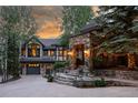 Stone facade home with stone archway entrance, a garage, and stairs leading to the front door at 222 Greystone Rd, Evergreen, CO 80439