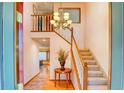 Bright foyer with hardwood floors, a staircase with white railings, and a chandelier at 20380 Silver Horn Ln, Monument, CO 80132