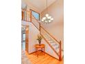 Welcoming foyer with wood floors, a staircase with white railings, and decorative chandelier at 20380 Silver Horn Ln, Monument, CO 80132