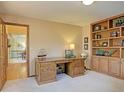 Comfortable home office with built-in shelves, a large desk, and carpeted floors at 20380 Silver Horn Ln, Monument, CO 80132