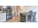 Cozy dining area adjacent to the kitchen with a view of the staircase and lots of natural light at 9369 Longs Peak Dr, Henderson, CO 80640