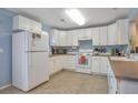 Bright kitchen featuring clean white cabinets, a tiled floor, and efficient appliances at 9369 Longs Peak Dr, Henderson, CO 80640