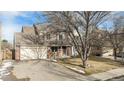 View of the exterior featuring a brick facade, attached garage, driveway, and well-maintained yard at 831 W Kettle Ave, Littleton, CO 80120