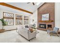 Living room featuring a fireplace, exposed beams, and large windows with backyard views at 831 W Kettle Ave, Littleton, CO 80120