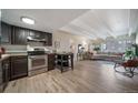 Open-concept living room and kitchen space featuring stainless steel appliances and hardwood floors, perfect for modern living at 33 N Corona St # 205, Denver, CO 80218