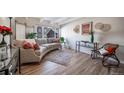 Bright living room with a curved sofa, hardwood floors, large windows, and stylish décor at 33 N Corona St # 205, Denver, CO 80218
