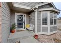 Inviting front porch with a white bench, potted plants, and a charming wreath on the front door at 2347 Switch Grass Way, Castle Rock, CO 80109