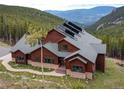 An exterior elevation showing the home with a stone foundation and solar panels at 76 Raven Ridge Rd, Idaho Springs, CO 80452