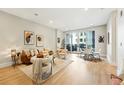 Bright living room with modern furniture, hardwood floors, neutral walls, and a sliding glass door to a balcony at 250 Columbine St # 310, Denver, CO 80206