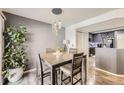 Cozy dining area with modern lighting, stylish table, and a view into the kitchen at 18865 E 57Th Ave # B, Denver, CO 80249