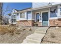Close-up of townhome front entrance, showing brick detail and blue painted door at 18865 E 57Th Ave # B, Denver, CO 80249