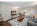 Cozy living room with sofa, wood floors, entertainment center and adjacent dining area at 3047 W 47Th Ave # 109, Denver, CO 80211