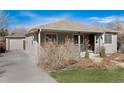 View of the home and detached garage showcasing the home's side entrance and manicured lawn at 2307 Moline St, Aurora, CO 80010