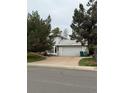 Side view of a well maintained home with a two car garage and an extended driveway at 3566 E Fair Pl, Centennial, CO 80121