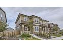 Charming two-story home showcasing its neutral color scheme, stone accents, and landscaped yard at 6233 N Liverpool St, Aurora, CO 80019