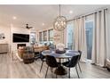 Open-concept living space with a stylish dining area featuring a modern chandelier and a comfortable living room with a fireplace at 431 Courtfield Way, Castle Pines, CO 80108