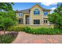 Beautiful home featuring an arched entryway, complemented by vibrant landscaping and a meticulously maintained front yard at 1564 S Uinta Way, Denver, CO 80231