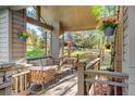 Relaxing covered porch featuring comfortable seating, hanging flower baskets, and serene views at 2873 Cortina Ln, Evergreen, CO 80439