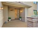 Charming covered front entrance with stone accents, tasteful lighting fixtures, and potted plants at 2873 Cortina Ln, Evergreen, CO 80439