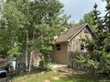 Charming home with neutral siding, mature trees, and a welcoming front entrance at 26212 Center Dr, Kittredge, CO 80457