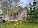 Charming home featuring a tidy lawn, wood fence, and rustic stone accents around the lower level at 26212 Center Dr, Kittredge, CO 80457