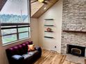 Cozy living room with stone fireplace, hardwood floors, and comfortable seating at 26212 Center Dr, Kittredge, CO 80457