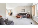 Spacious living room featuring neutral carpet, a large sofa, and ample natural light at 466 S Kingston Cir, Aurora, CO 80012