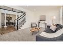 Bright living room featuring neutral color palette, plush carpet, and staircase with black and white banister at 3549 Mallard Dr, Highlands Ranch, CO 80126