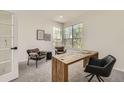 Home office features a unique wood desk, comfortable seating and lots of natural light from corner windows at 3549 Mallard Dr, Highlands Ranch, CO 80126