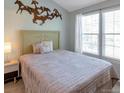Bedroom featuring a comfortable bed, horse wall art, and a window letting in natural light at 9640 W Chatfield Ave # A, Littleton, CO 80128