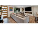 Bright living room featuring hardwood floors, a stylish sectional sofa, large windows, and an electric fireplace at 1260 Hoyt St, Lakewood, CO 80215