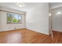 Sunny bedroom with gleaming hardwood floors, neutral walls, and a large window at 2816 S Wolff St, Denver, CO 80236