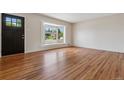 Bright living room featuring gleaming hardwood floors, a large bay window, and neutral walls at 2816 S Wolff St, Denver, CO 80236