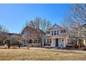 Traditional two-story home with manicured front yard and covered porch seating, perfect for relaxing outdoors at 2362 Xanthia Way, Denver, CO 80238